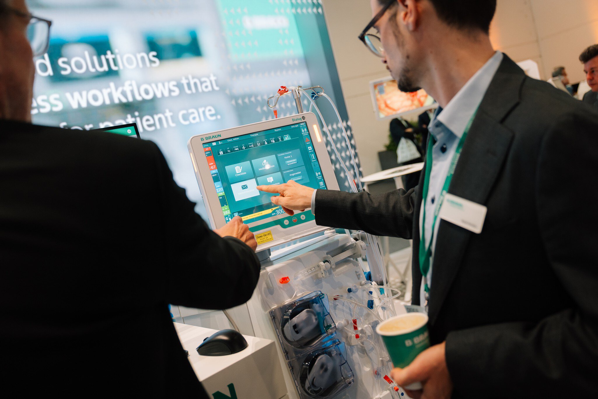 Attendees using a digital medical device with touchscreen at DMEA