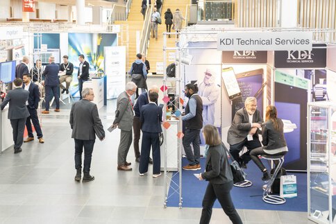 Menschen besuchen Stände auf der LOPEC Messe, führen Gespräche an den Ständen und tauschen Informationen aus.