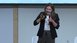 A woman in a black blazer speaks using a microphone at bauma.