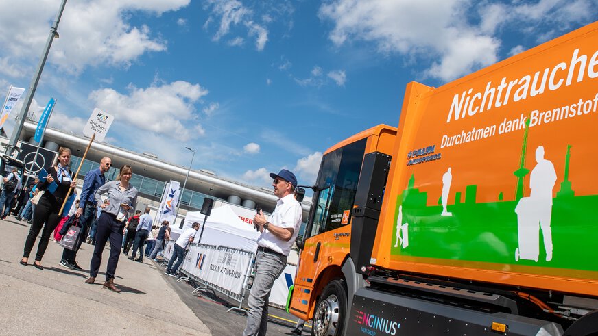 A male exhibitor explains his solution to one of the challenges facing the environmental industry to a group of participants on the IFAT Munich Solution Tour