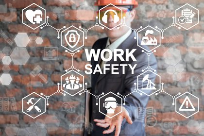 A man in a suit and hard hat points to safety icons, the text 