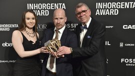 Drei Personen halten die Trophäe der Kategorie „Watch Design of the Year“  bei der INHORGENTA AWARD-Gala vor einer Logowand.