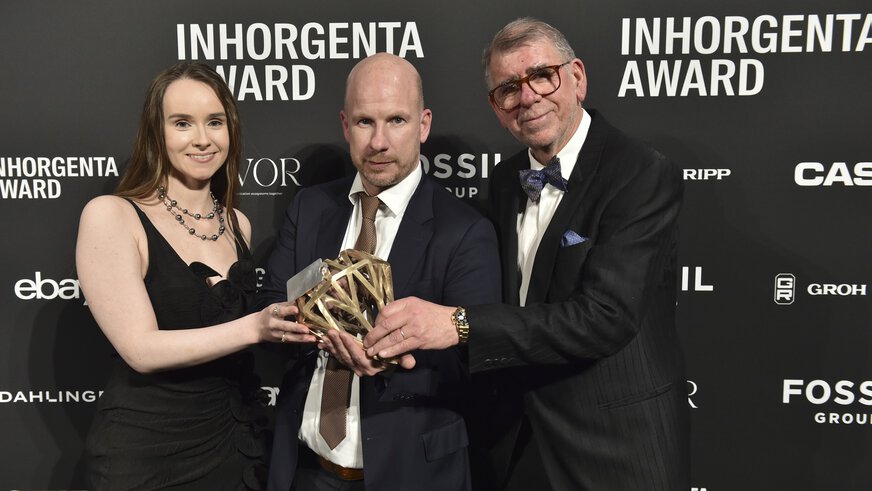 Three people hold the trophy in the “Watch Design of the Year” category at the INHORGENTA AWARD Gala in front of a logo wall.