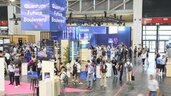 Reges Treiben auf dem Quantum Future Boulevard der World of Quantum in München mit zahlreichen Besucher:innen und Ausstellerständen.