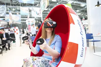 Auf der Tourismusmesse: Frau mit VR-Brille beim einer Virtual Reality Kroatienreise