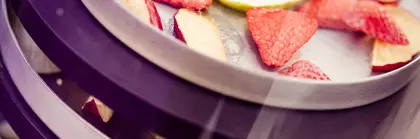 Erdbeer- und Apfelstücke liegen auf einer Art dreistöckigen Tablettvorrichtung