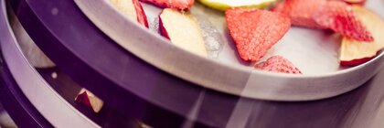 Erdbeer- und Apfelstücke liegen auf einer Art dreistöckigen Tablettvorrichtung