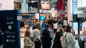Belebte DMEA Messehalle mit Ausstellungsständen und Fachbesuchern