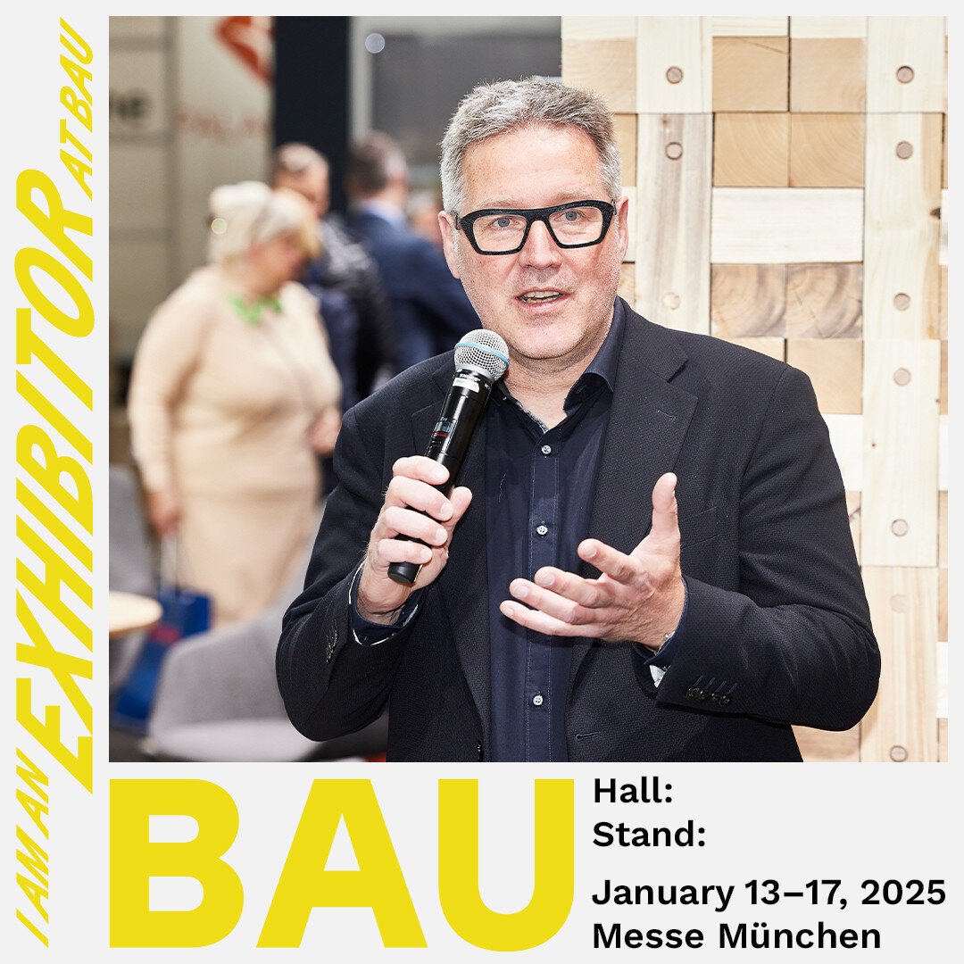 Ein Mann mit eckiger Brille und schwarzem Jackett hält ein Mikrofon in der Hand. Daneben steht „I AM AN EXHIBITOR AT BAU“ und die Messedaten der BAU.
