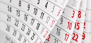 Mehrere Seiten eines Kalenders, mit schwarzen Zahlen und rot markierten Sonntagen.