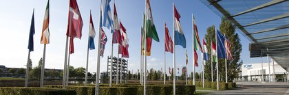 Several national flags, on flagpoles in front of the main entrance to Messe München.
