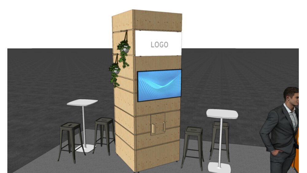 Messestand mit Holzpaneel, Paravent, Hockern, Tischen und einer vertikalen Pflanzenfigur. Mann steht in der Nähe.
