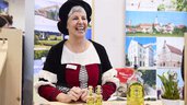 Ausstellerin in Tracht präsentiert gut gelaunt Oberbayerns Reise-Highlights.