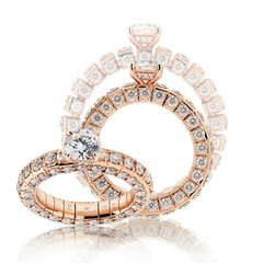 Three wide, multi-section rings set with numerous round diamonds and each featuring a large gemstone set on the side.