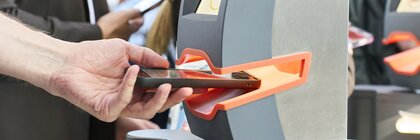 Besucher passieren die digitalen Zugangskontrollen der Laser World of Photonics im Eingangsbereich der Messe München.