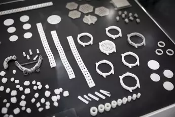 Various white and grey geometric pieces arranged on a black surface.