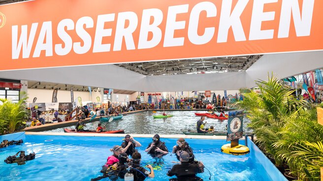 Blick auf ein großes Wasserbecken in einer Messehalle.