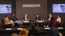 Six people sit in a semicircle on a stage at INHORGENTA and discuss in front of an audience how to make jewellery purchases attractive to Gen Z.