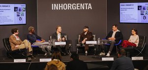 Six people sit in a semicircle on a stage at INHORGENTA and discuss in front of an audience how to make jewellery purchases attractive to Gen Z.