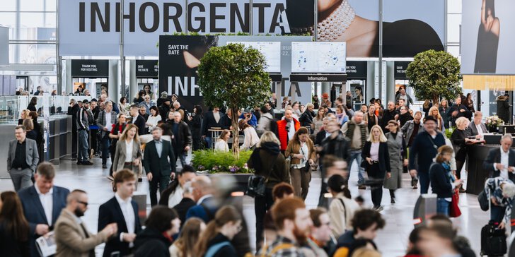 Numerous trade fair visitors are making their way through an entrance hall at INHORGENTA towards the security checks. Two ornamental trees stand amongst the visitors.
