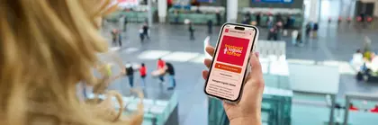 Eine Frau hält ein Smartphone in der Hand, auf dem man den transport logistic Podcast sieht.