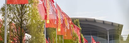 Rote Fahnen mit gelber und weißer Aufschrift 