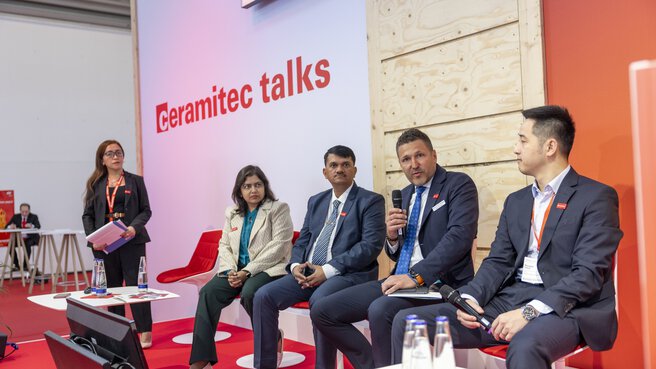 Vier Personen sitzen auf der Bühne der 