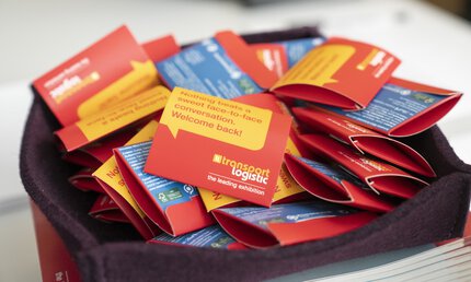 Eine große Menge roter-gelber Päckchen zur transport logistic, auf der 