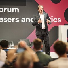 Ein Redner präsentiert auf dem Forum „Lasers and Photonics“ der Messe Laser World of Photonics vor Publikum aktuelle Themen aus der Photonikbranche.