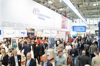 Gut besuchte Messestände der transport logistic aus der Vogelperspektive mit Fokus auf ein Banner mit dem Logo der 