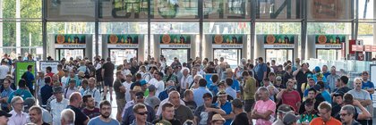 Zahlreiche Besucher der INTERFORST warten am Eingang Ost der Messe München vor den Ticketscannern auf den Einlass.
