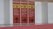 Red and yellow signs on partition walls with instructions, including 
