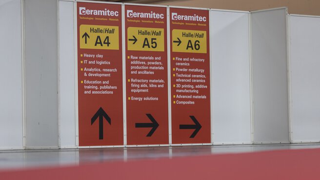 Red and yellow signs on partition walls with instructions, including 