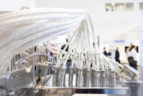 Close-up of an industrial machine on display with several cables connected, at a trade fair stand.