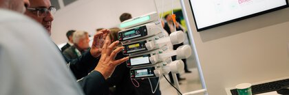 Besucher betrachten ein digitales Infusionssystem an einem Medizintechnik-Stand