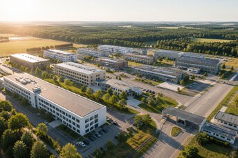 Aerial view of a modern military base with administrative and logistics buildings in a green landscape.