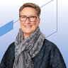 Porträt einer Frau mit kurzem Haar in dunkler Jacke mit Kreismuster und grauem Schal vor einem hellen Hintergrund mit blauen grafischen Linien
