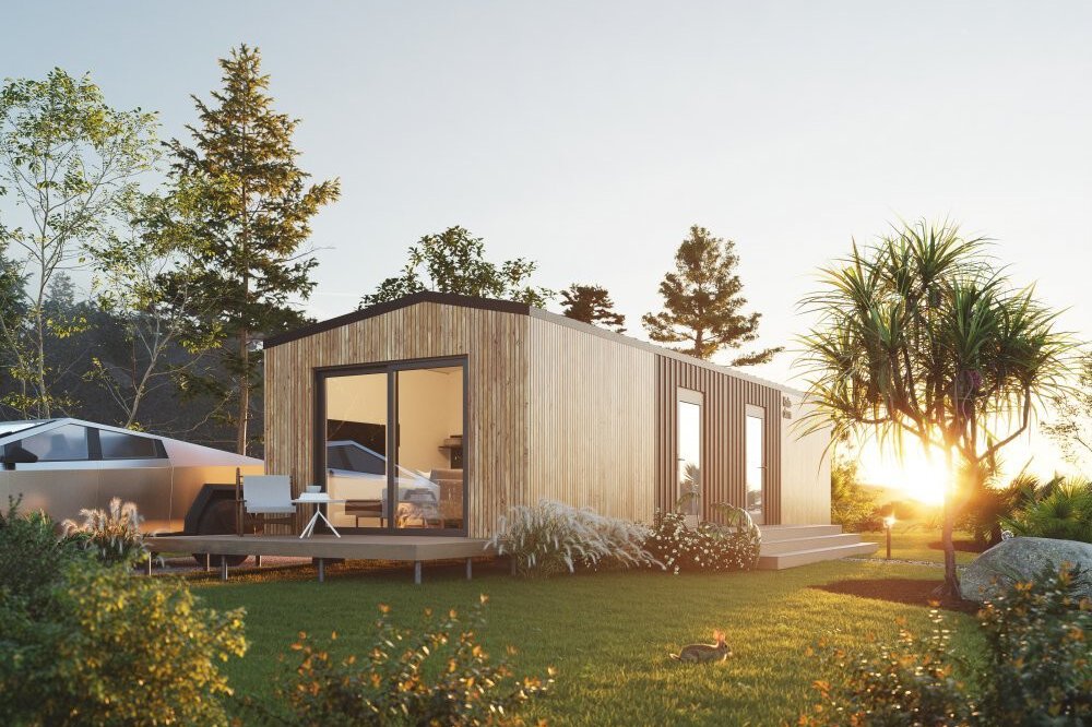 Moderne Holzhütte mit großen Fenstern, umgeben von Bäumen und Gras, bei Sonnenuntergang. Auf dem Rasen sitzt ein kleiner Hase.
