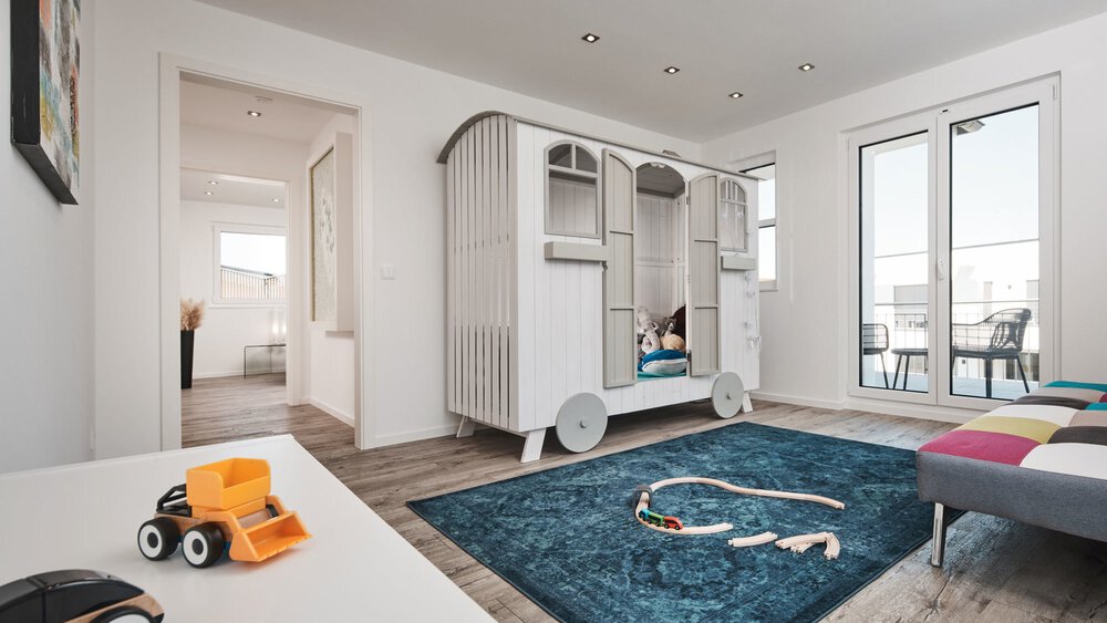 Helles Kinderzimmer mit Spielzeug-Wohnwagenbett, Spielzeug auf dem Boden und großen Fenstern, die natürliches Licht hereinlassen.