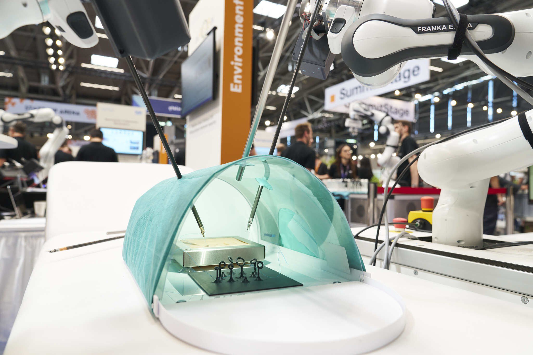 Roboterarm führt medizinische Simulation mit Instrumenten unter grüner Abdeckung aus.