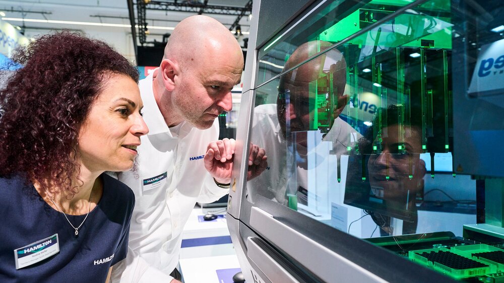 Two people are looking at a piece of laboratory equipment