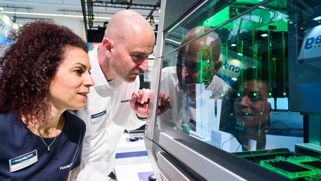 Two people are looking at a piece of laboratory equipment