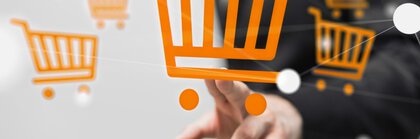 A hand taps on an orange shopping cart symbol on a transparent screen.