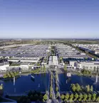 Aerial view of the Messesee lake, the halls and other buildings of the Munich Trade Fair Centre. Approximately one third of the picture shows the cloudless sky.