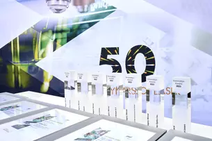 Presentation of several Innovation Awards 2023 on a table against the backdrop of “50 years”.