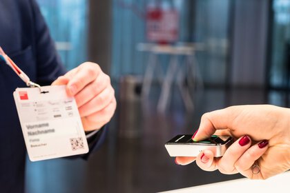 Ein Namebadge wird präsentiert, während eine Person diesen mit einem Gerät in ihrer Hand scannt.