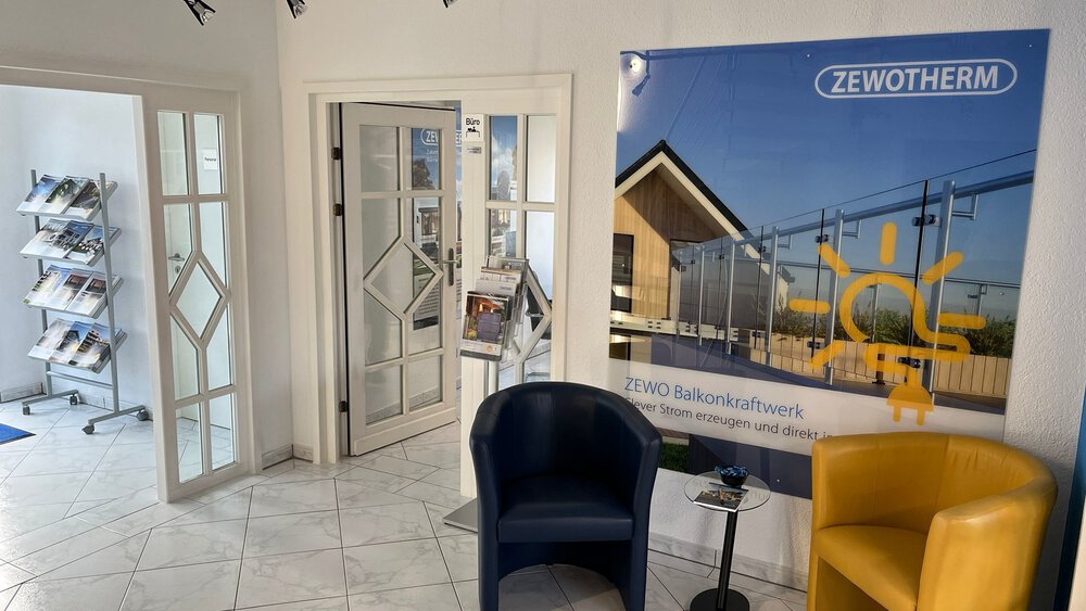 Moderner Büro-Wartebereich mit zwei Stühlen, einem Tisch, Broschüren und einem ZEWO-Poster an der Wand.