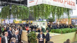 View of the EXPO REAL Grand Plaza with numerous visitors, networking areas, and the Grand Plaza Stage.