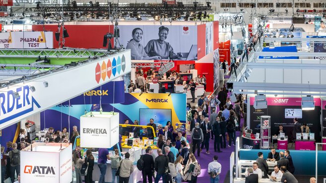 A packed exhibition hall viewed from above