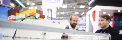 Demonstration eines maritimen Technologie-Exponats mit Unterwasserkomponenten auf einem Messestand der Laser- und Photonikbranche.